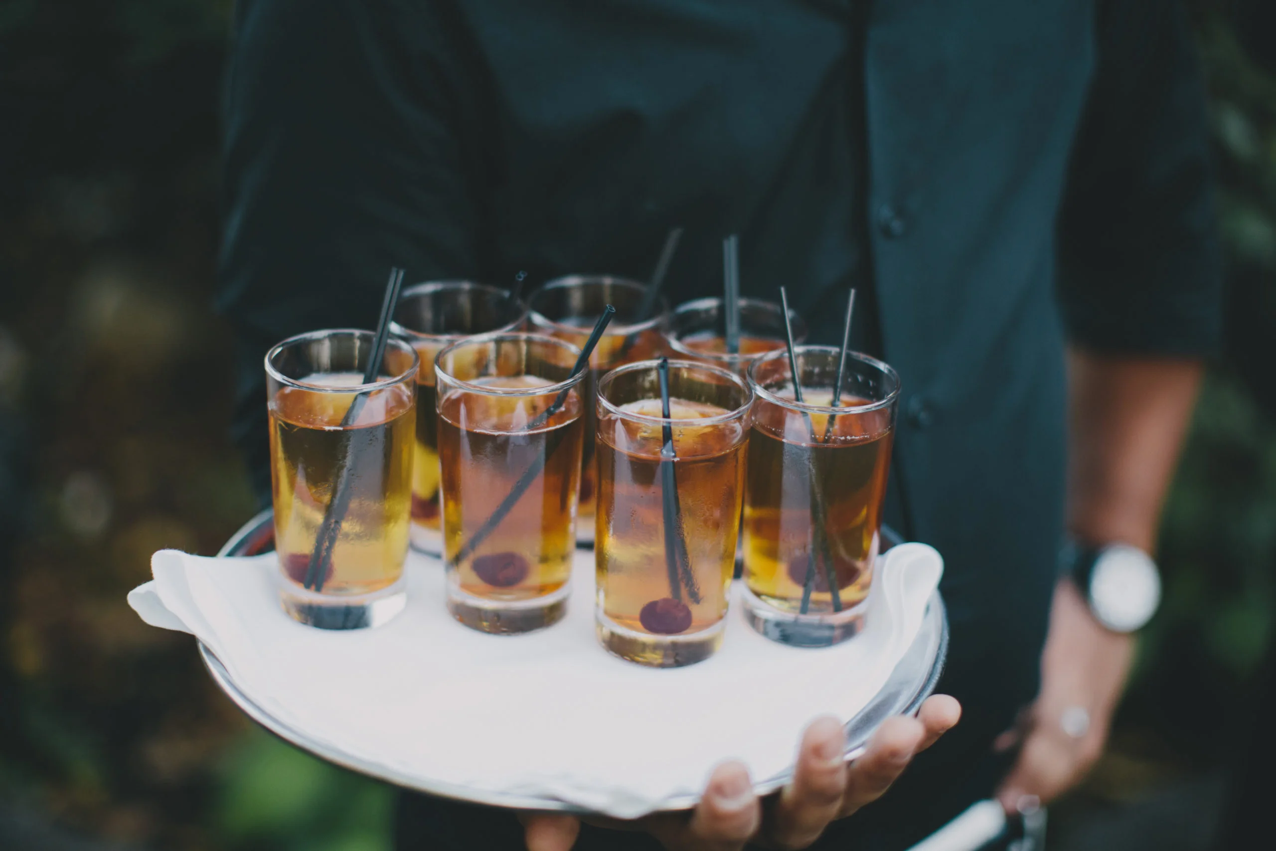 MAN HOLDING A TRAY OF DRINKS